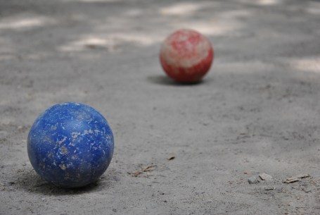 Boccia blu e boccia rossa su terreno grigio
